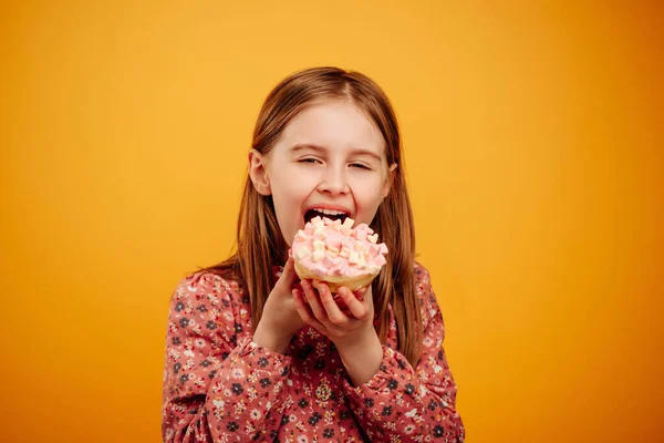 Sarı arka planda izole edilmiş donutlu kız — Stok fotoğraf