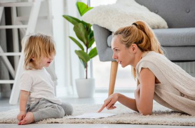 Anne oğluyla çiziyor.