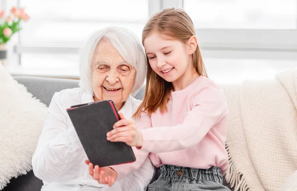 Mormor med dotterdotter som använder tabletter — Stockfoto