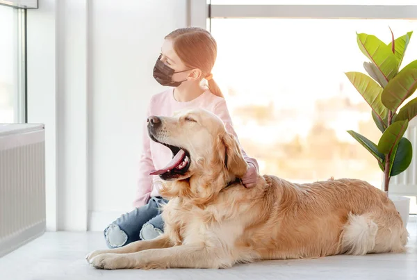 Menina em máscara com cão golden retriever — Fotografia de Stock