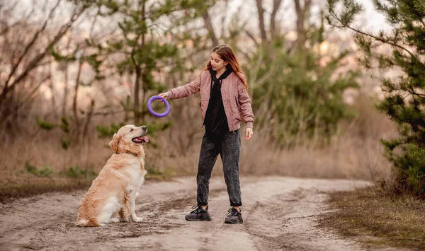 Dziewczyna z psem golden retriever w lesie — Zdjęcie stockowe