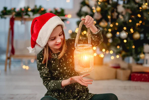 산타 모자를 쓰고 촛불을 들고 있는 소녀 — 스톡 사진