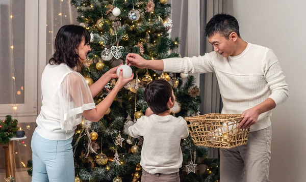 Feliz familia decorando el árbol de Navidad juntos —  Fotos de Stock
