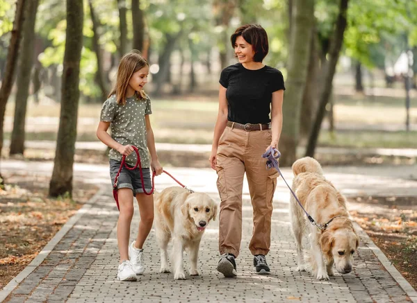 Мать и дочь с золотой собакой-ретривером — стоковое фото