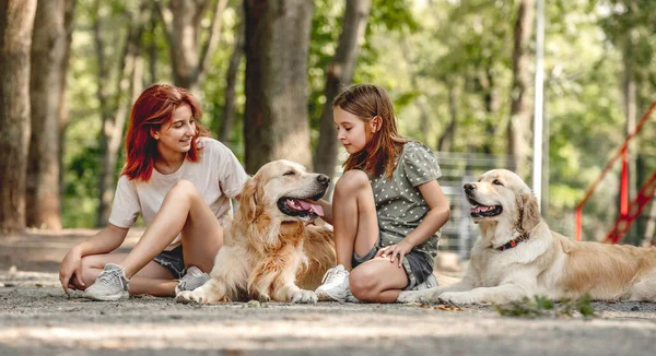 Flickor med golden retriever hundar — Stockfoto