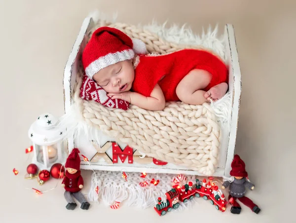 Neugeborenes im Weihnachtsmann-Anzug ruht auf Bett — Stockfoto