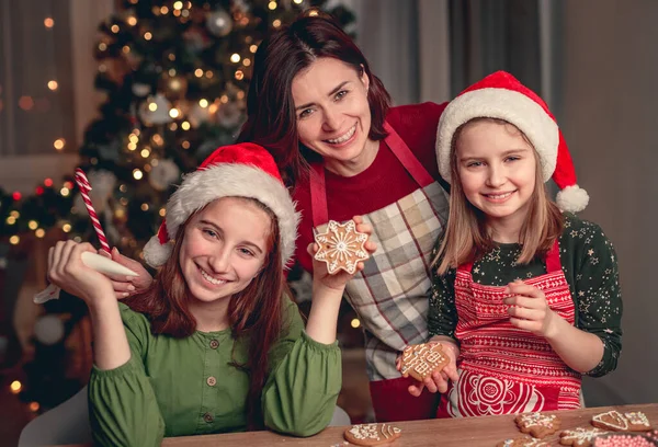 Sorridente madre con figlie che cuociono pan di zenzero — Foto Stock