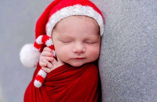 Newborn sleeping with knitted christmas candy — Stock Photo, Image