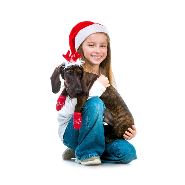 Fille dans le chapeau du Père Noël avec un teckel — Photo