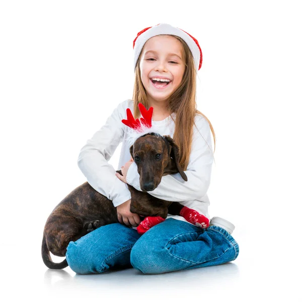 Fille dans le chapeau du Père Noël avec un teckel — Photo