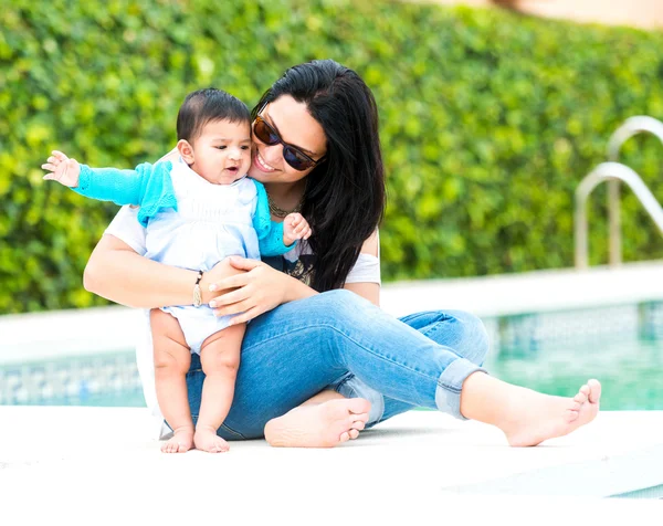 Mor med baby nära poolen — Stockfoto