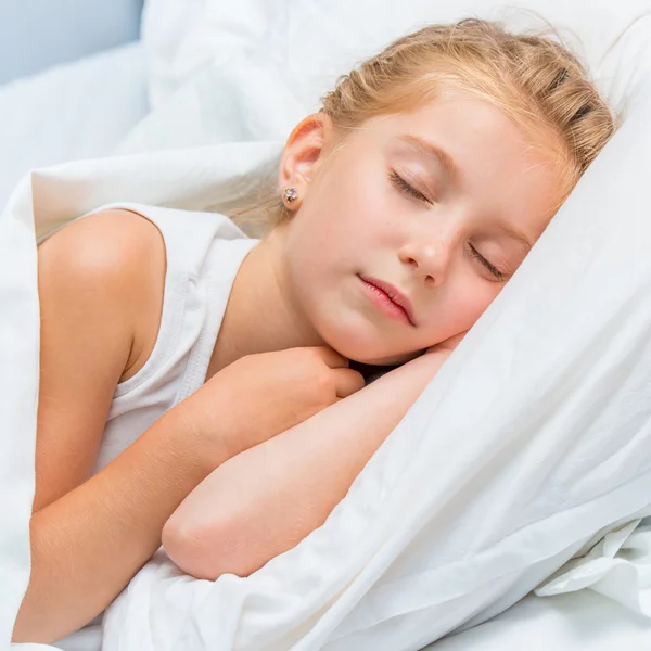 Bambina che dorme nel letto bianco — Foto Stock