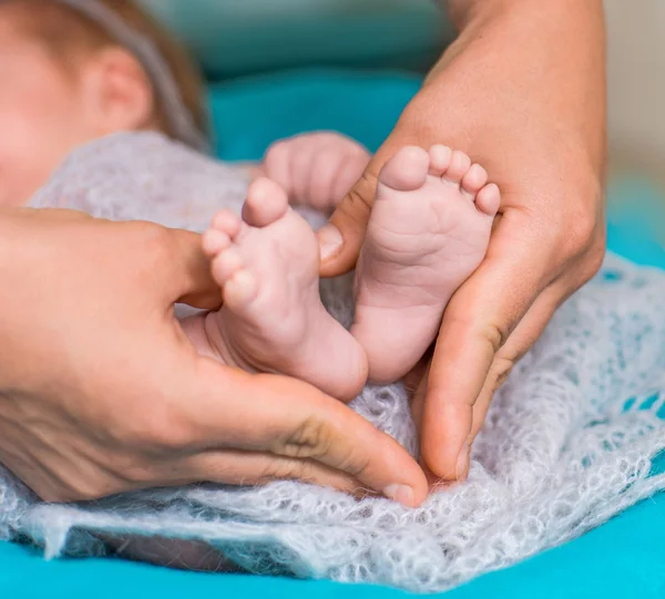 Piedi del bambino su mani femminili — Foto Stock