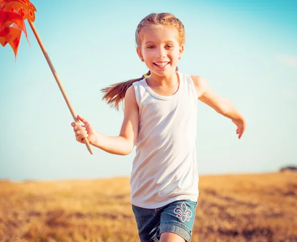 Nettes kleines Mädchen mit einer Windmühle — Stockfoto