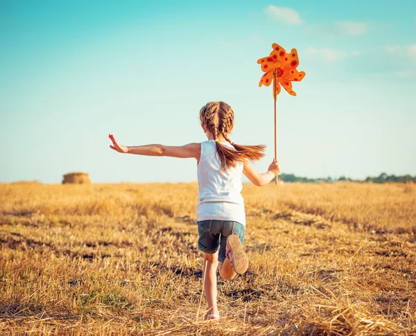 Menina bonito com um moinho de vento — Fotografia de Stock