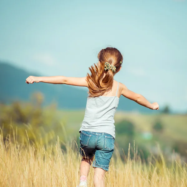 Little girl runs through a meadow — Stock Photo, Image