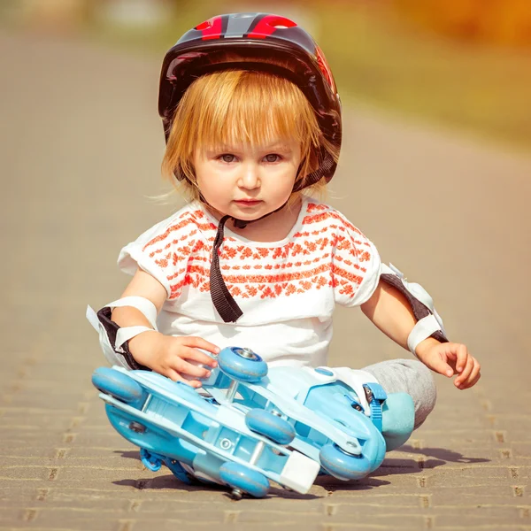Menina em patins e um capacete — Fotografia de Stock