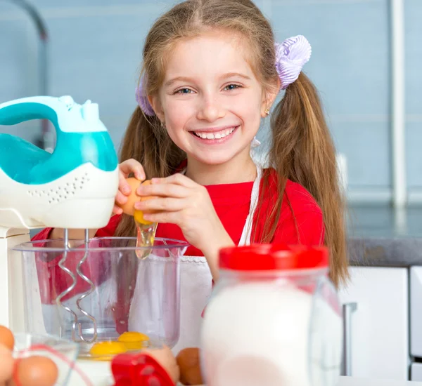 Girl breaks egg in cookie dough — Stock Photo, Image