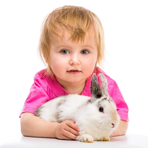 Niña en una camiseta rosa con su pequeño conejo blanco de cerca —  Fotos de Stock