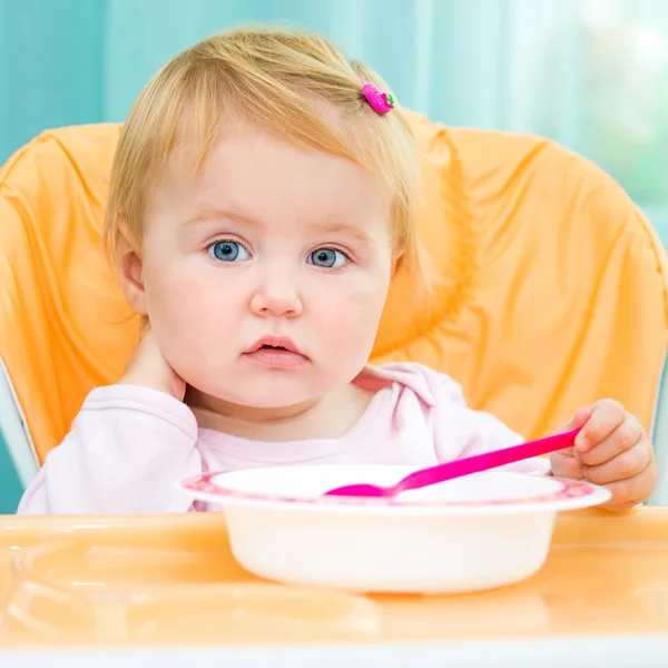 Menina em uma cadeira alta para alimentação — Fotografia de Stock