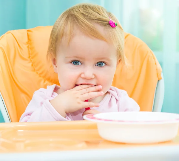 Menina em uma cadeira alta para alimentação — Fotografia de Stock