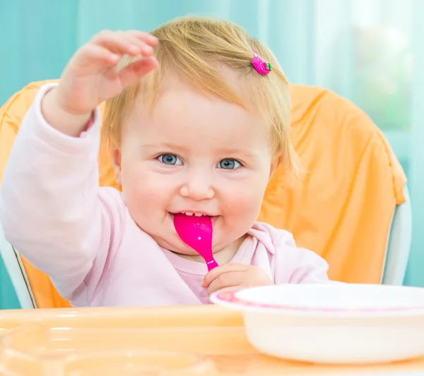 Meisje in een hoge stoel voor het voederen — Stockfoto