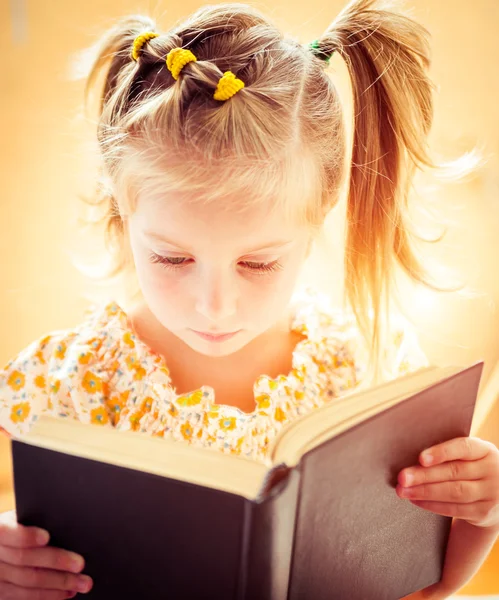 Kleines Mädchen liest das Buch — Stockfoto