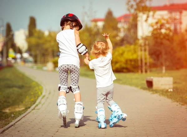 Маленькие сестры на роликовых коньках — стоковое фото