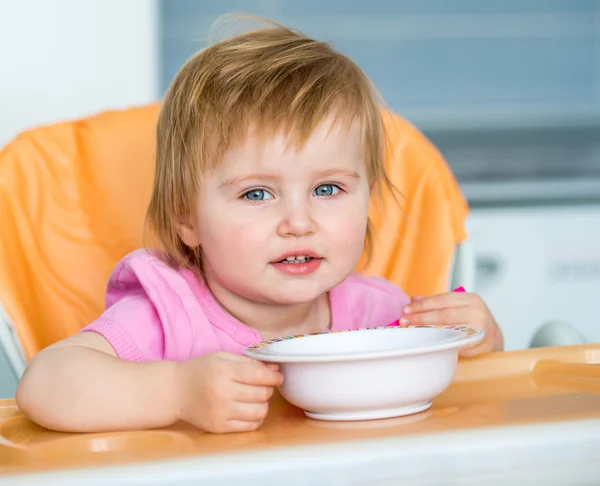 Bébé fille avec cuillère et assiette — Photo