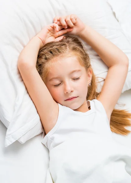 Kleines Mädchen schläft im weißen Bett — Stockfoto