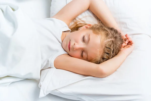 Liten flicka sova i vit säng — Stockfoto