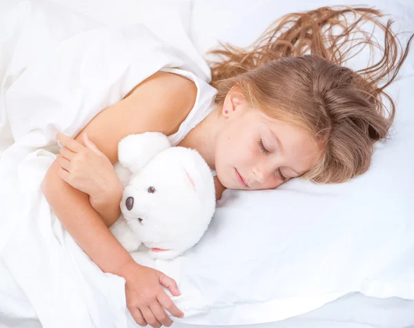 Mädchen im Bett mit Teddybär — Stockfoto