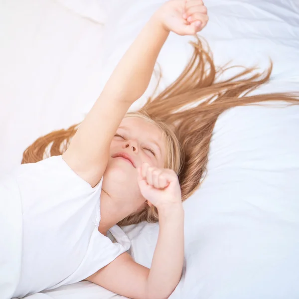 Girl lying in white bed — Stock Photo, Image