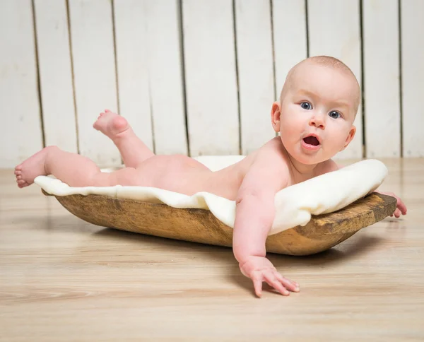 Menina bebê em cocho de madeira — Fotografia de Stock