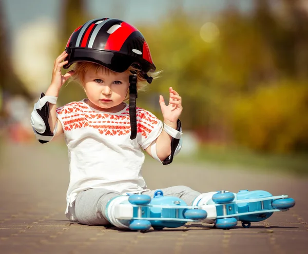 Ragazza di due anni in pattini a rotelle e un casco — Foto Stock