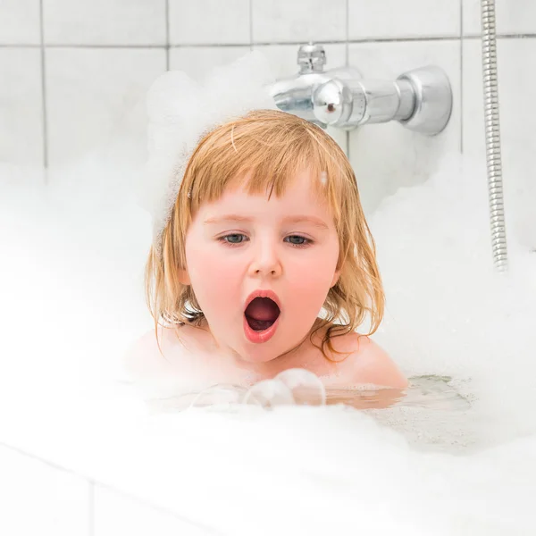 Bonito dois anos de idade bebê banhos em um banho com espuma — Fotografia de Stock
