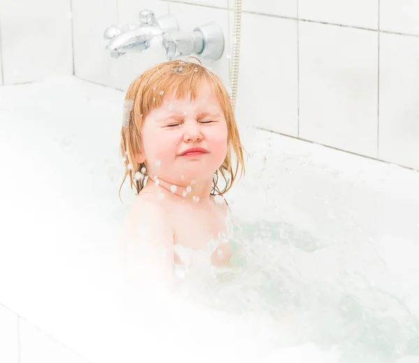 Bonito dois anos de idade bebê banhos em um banho com espuma — Fotografia de Stock