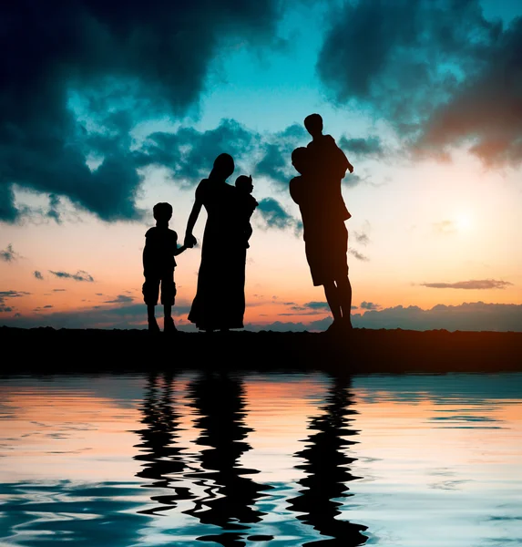 Family on  background of magnificent sunset — Stock Photo, Image