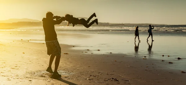 Papá jugando con su hija en la playa — Foto de Stock