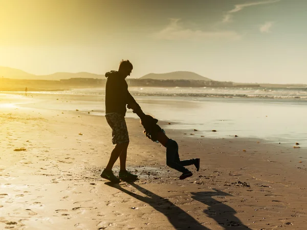 Papa spielt mit Tochter am Strand — Stockfoto