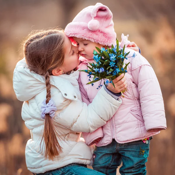 Маленькая девочка целует свою сестру — стоковое фото