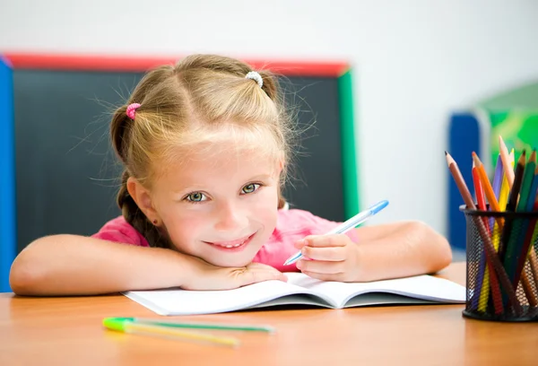 Schönes kleines Mädchen am Schreibtisch — Stockfoto