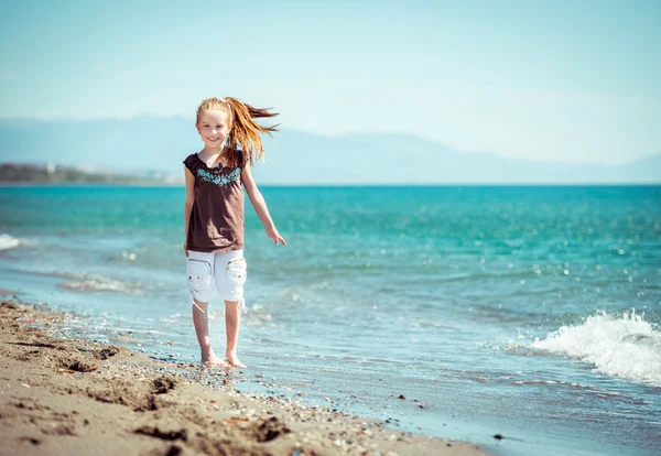 Liten flicka på tropisk strand — Stockfoto