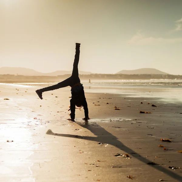 Little gymnast silhouette on  beach — Stock Photo, Image