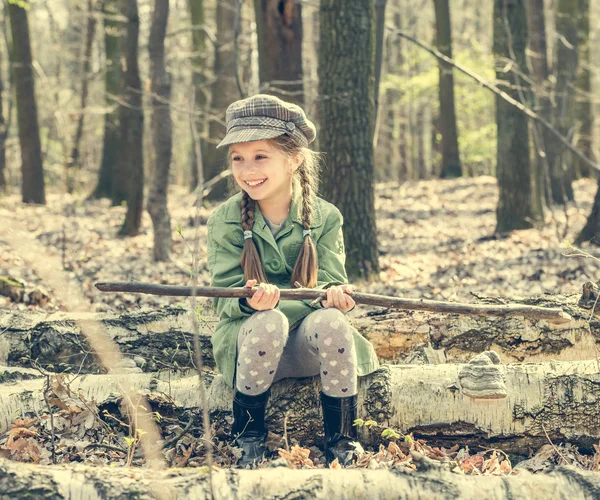 Girl in woods sitting on a stump — Stock Photo, Image