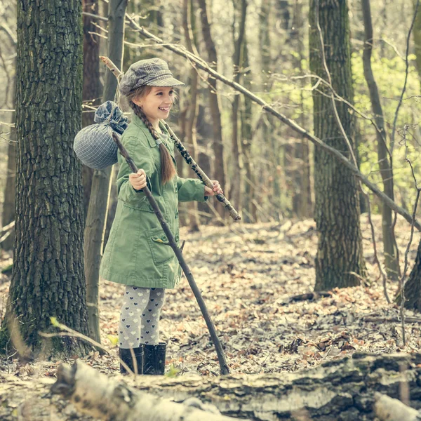 Liten flicka går genom skogen — Stockfoto