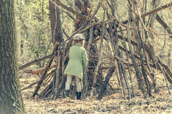 小さな女の子が森の中の小屋をビルドします。 — ストック写真