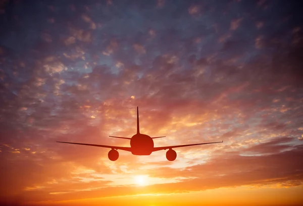 Vliegtuig in de lucht bij zonsondergang — Stockfoto