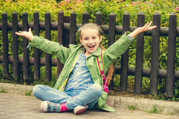 Hübsche Schulmädchen sitzt auf der Straße — Stockfoto