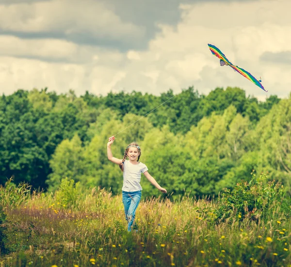 Маленькая милая девочка запускает воздушного змея — стоковое фото